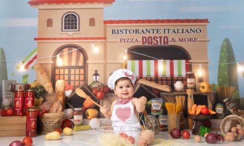 Adorable baby dressed as a little chef playing with spaghetti during a Baby Chef Photoshoot in Sydney at Blossom Brook Studio.