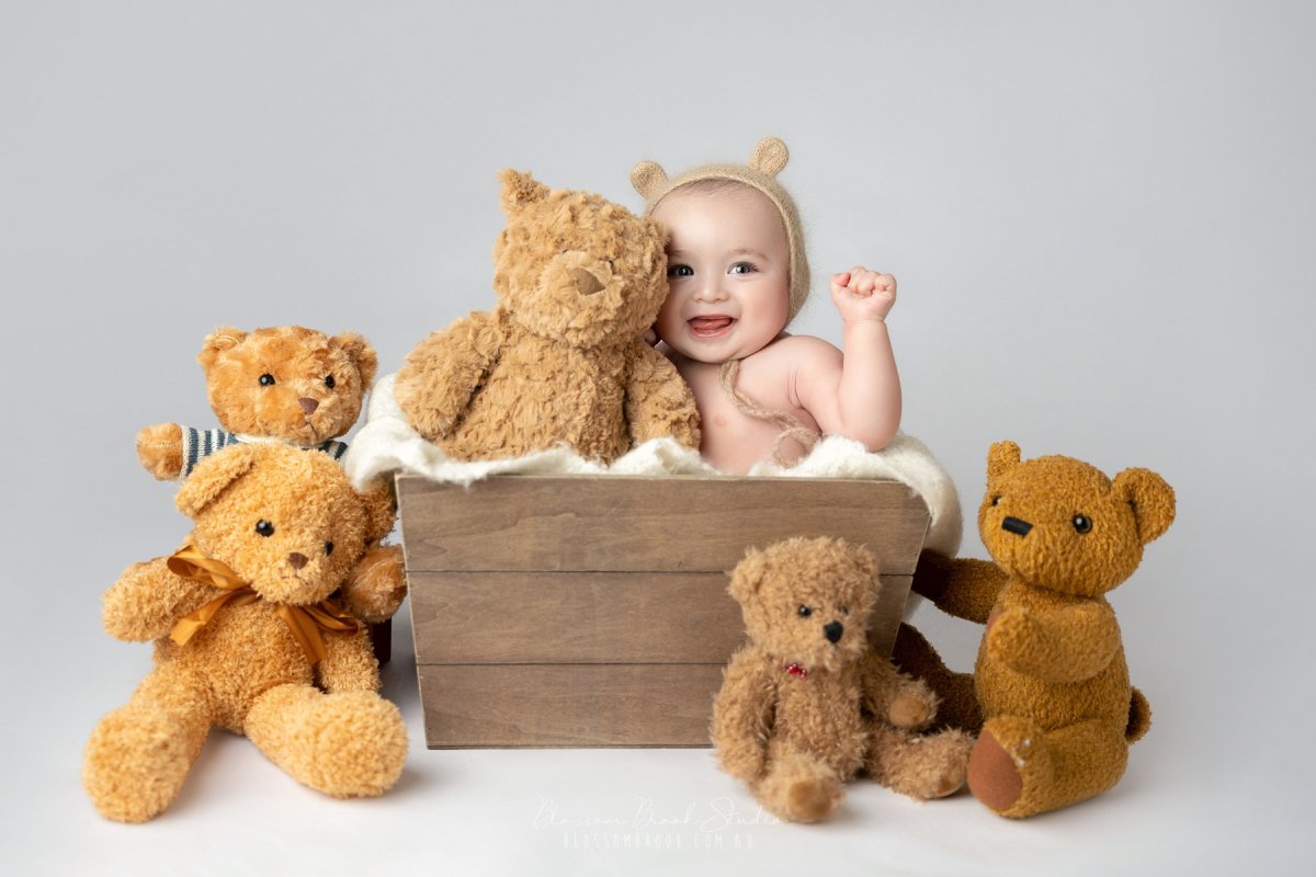 Baby surrounded by plush teddy bears.