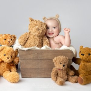 Baby surrounded by plush teddy bears.