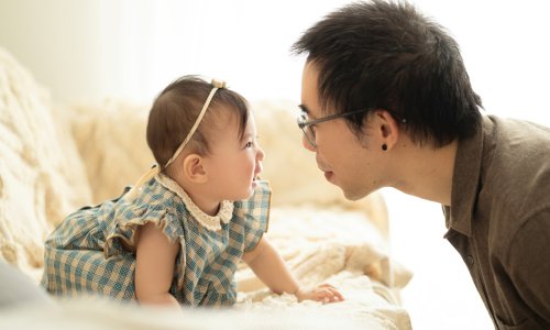 A heartwarming moment between a father and his baby during a Family Photography Sydney session at Blossom Brook Studio, capturing love and laughter in natural light.