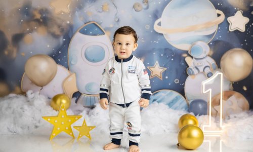 Adorable baby dressed as an astronaut during a space-themed First Birthday Photoshoot Sydney by Blossom Brook Studio, surrounded by planets, stars, and balloons.