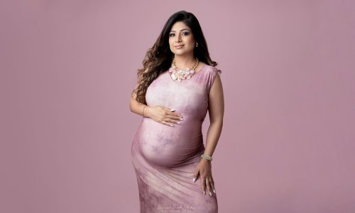 Pregnant woman in elegant pink dress.