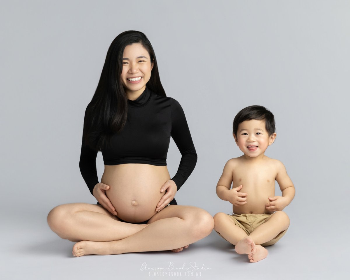 Pregnant woman with child, serene pose.