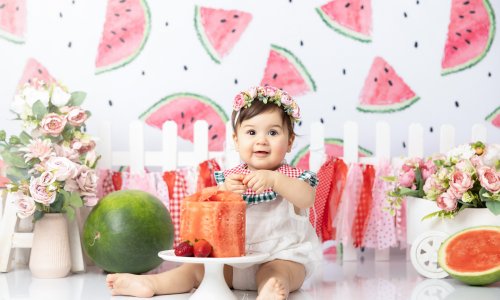 Adorable 10-month-old baby girl enjoying a watermelon-themed photoshoot in Sydney with summer fruits, flowers, and bright, cheerful décor, captured by Blossom Brook Studio.