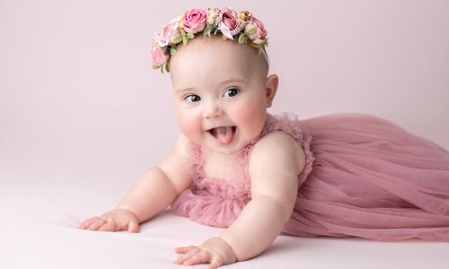Beautiful baby girl in a pink dress and floral crown during a professional baby photography Sydney session by Blossom Brook Studio.